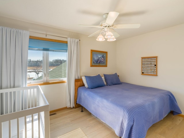 bedroom featuring a ceiling fan, wood finished floors, and baseboards