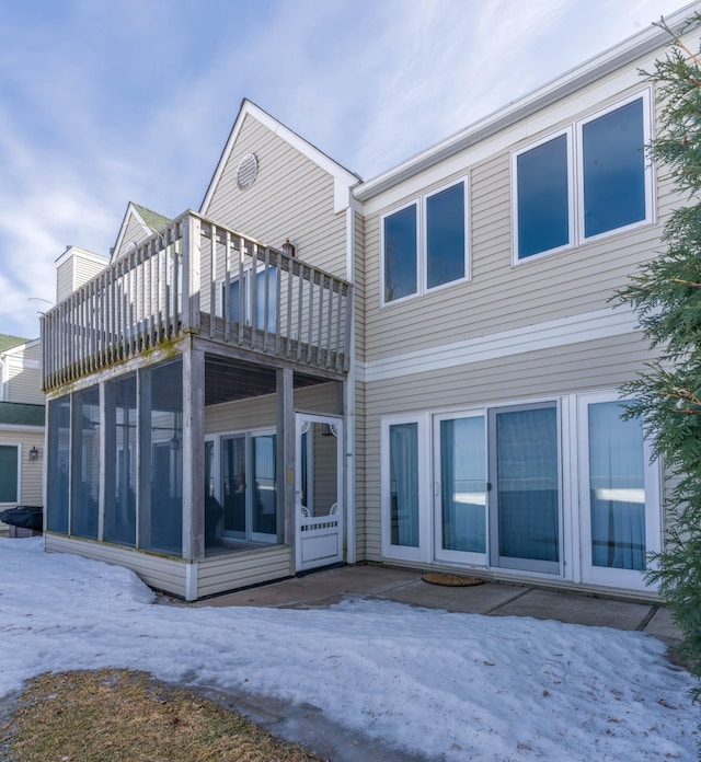 rear view of house featuring a sunroom