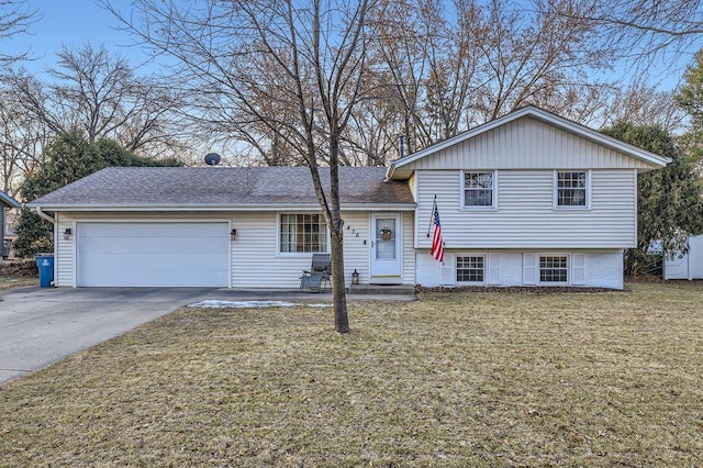 tri-level home featuring a garage, concrete driveway, and a front lawn