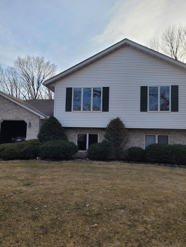 view of side of property with brick siding and a lawn