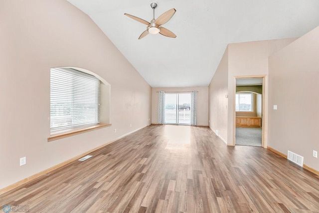 unfurnished living room with visible vents, lofted ceiling, a ceiling fan, and wood finished floors