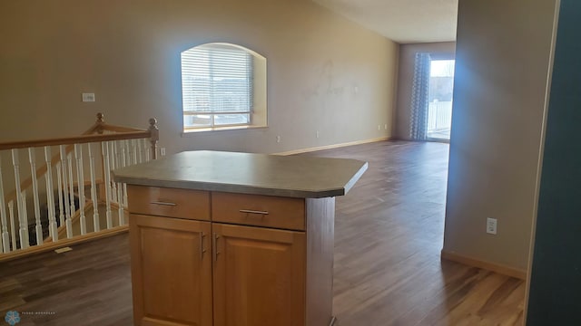 kitchen featuring baseboards, dark wood-style flooring, and a kitchen island