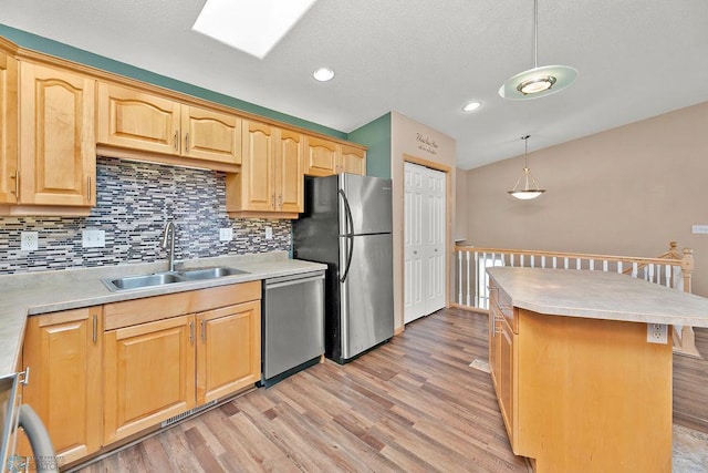 kitchen featuring a sink, stainless steel appliances, light wood-type flooring, and light countertops