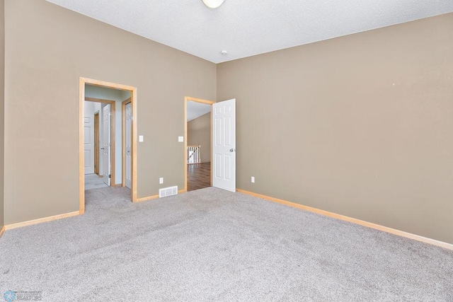 unfurnished bedroom featuring visible vents, baseboards, a textured ceiling, and carpet floors