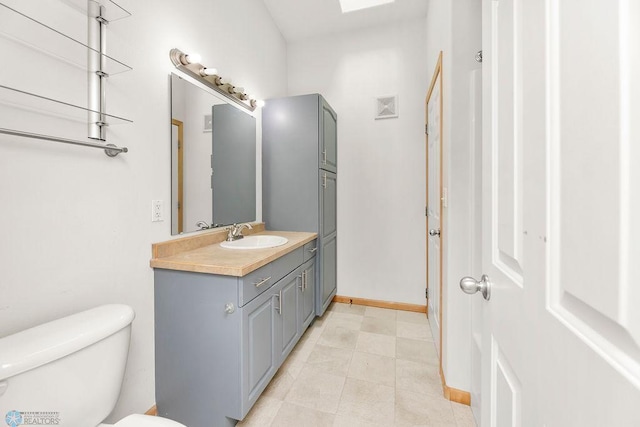 bathroom featuring vanity, toilet, and baseboards