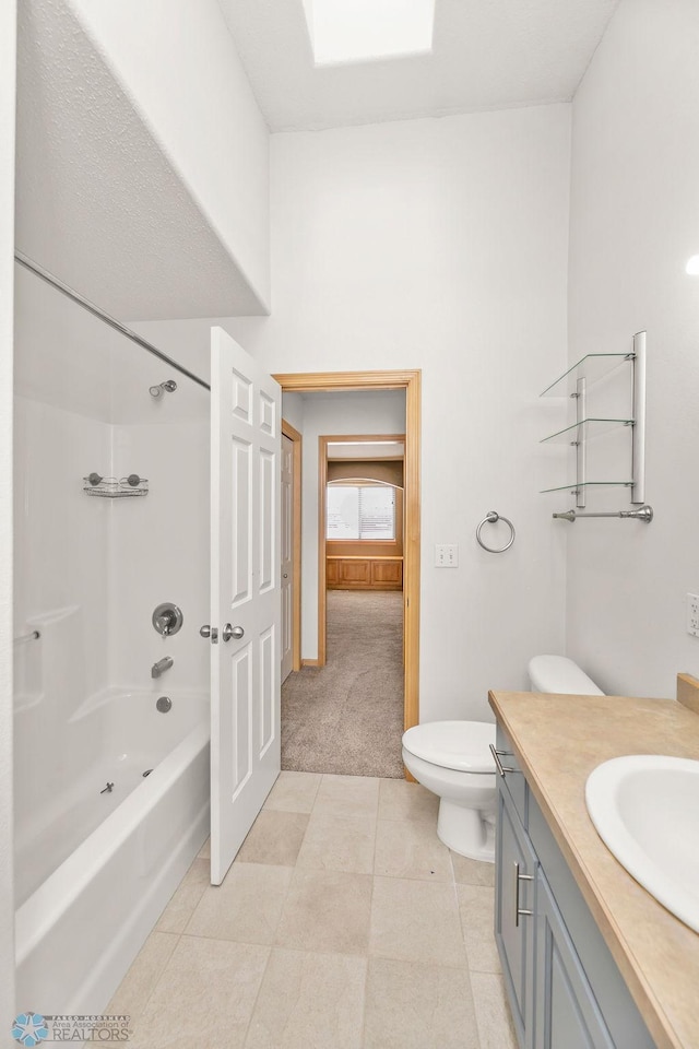 full bath with tub / shower combination, toilet, vanity, and tile patterned flooring