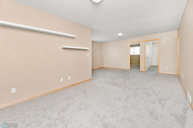 interior space with baseboards, carpet floors, and a textured ceiling