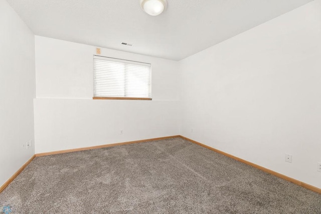 carpeted empty room featuring baseboards