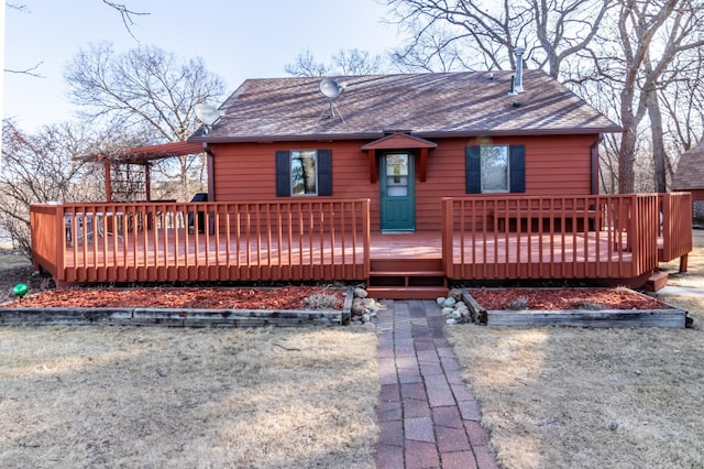 rear view of property featuring a wooden deck and a shingled roof