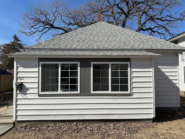 view of home's exterior featuring a chimney and a shingled roof