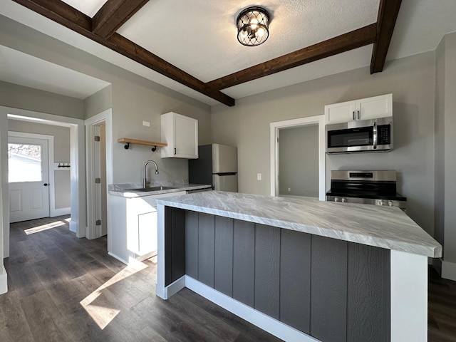 kitchen with dark wood-style flooring, white cabinets, appliances with stainless steel finishes, and a sink