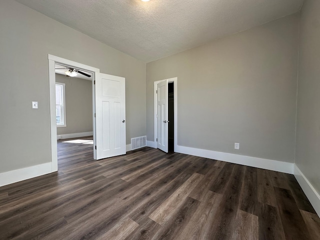 unfurnished bedroom featuring dark wood finished floors, baseboards, and visible vents