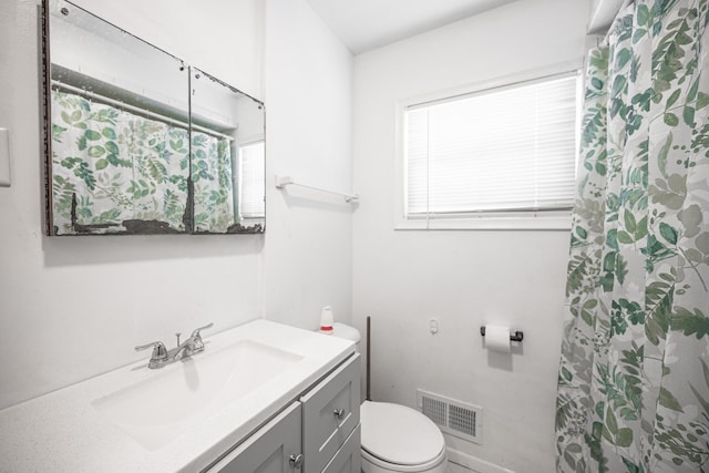 bathroom featuring vanity, a shower with shower curtain, toilet, and visible vents