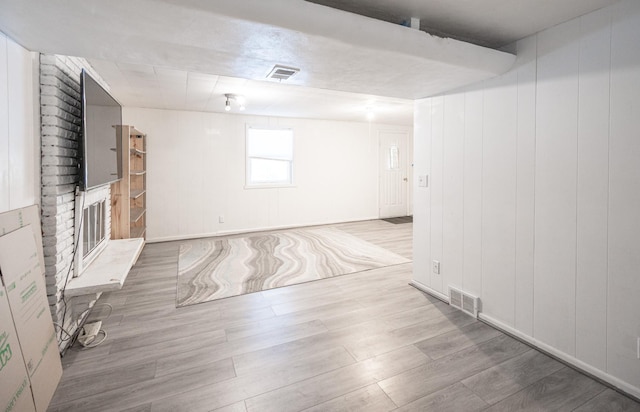 unfurnished living room featuring visible vents, wood finished floors, and a fireplace