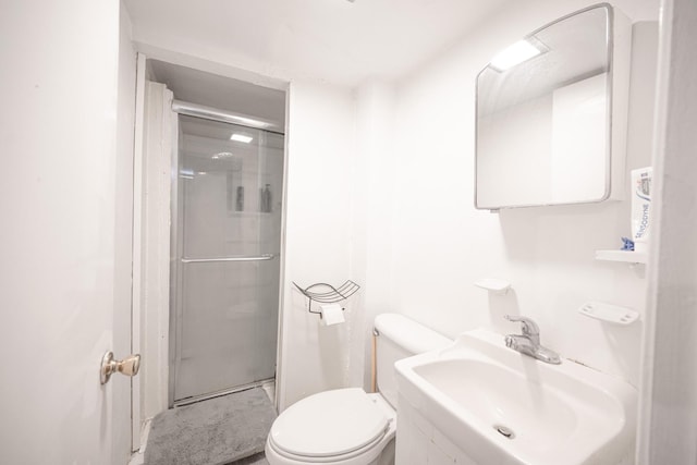 bathroom with a shower stall, toilet, and a sink