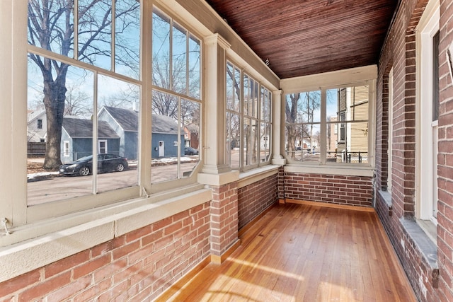 unfurnished sunroom with a residential view and wood ceiling