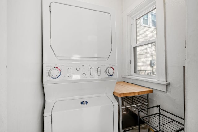 clothes washing area with plenty of natural light and stacked washer / dryer