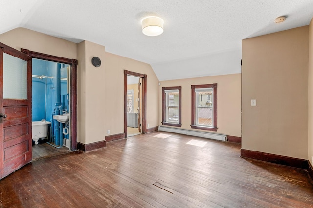 unfurnished living room with hardwood / wood-style floors, baseboards, vaulted ceiling, a textured ceiling, and baseboard heating