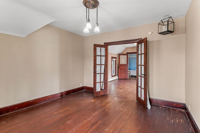 spare room with baseboards, lofted ceiling, hardwood / wood-style flooring, french doors, and a textured ceiling