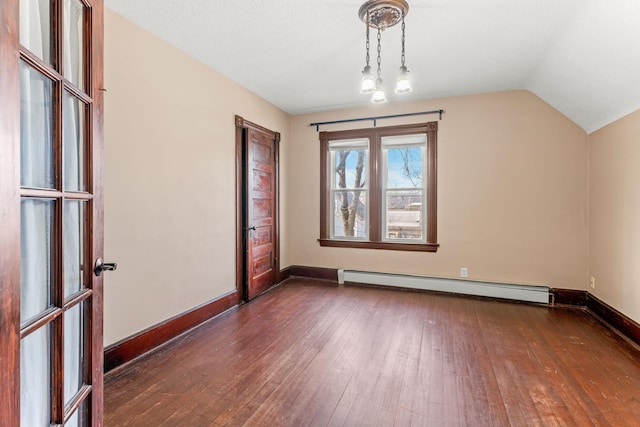 interior space with a baseboard heating unit, vaulted ceiling, dark wood-style floors, and baseboards