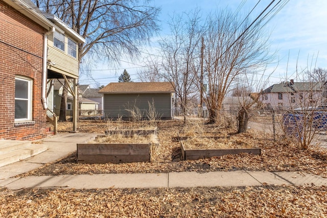 view of yard featuring an outbuilding, a vegetable garden, and fence