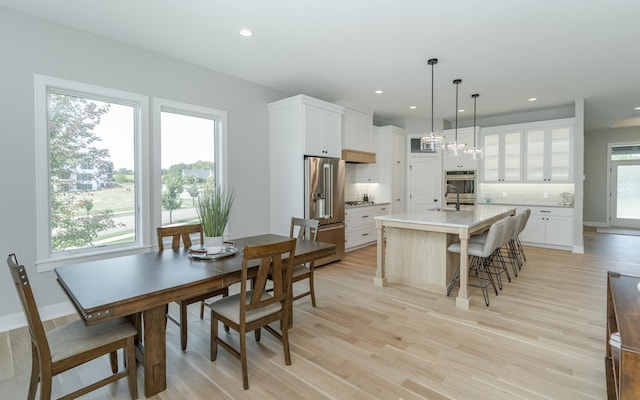 dining room with light wood finished floors, recessed lighting, and baseboards