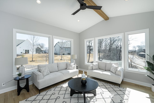 living room with vaulted ceiling with beams, wood finished floors, visible vents, and baseboards