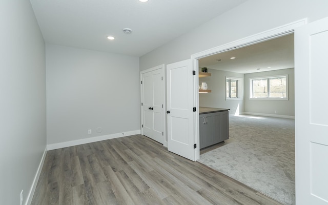 empty room featuring recessed lighting, baseboards, and wood finished floors