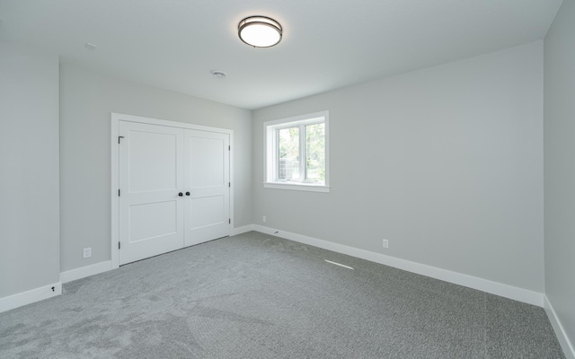 unfurnished bedroom with a closet, baseboards, and carpet