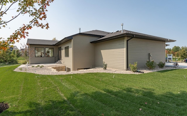 back of property featuring a lawn and entry steps