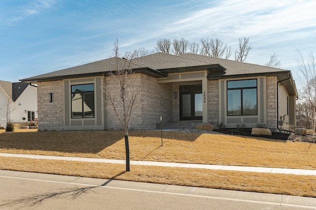 prairie-style house with stone siding and roof with shingles