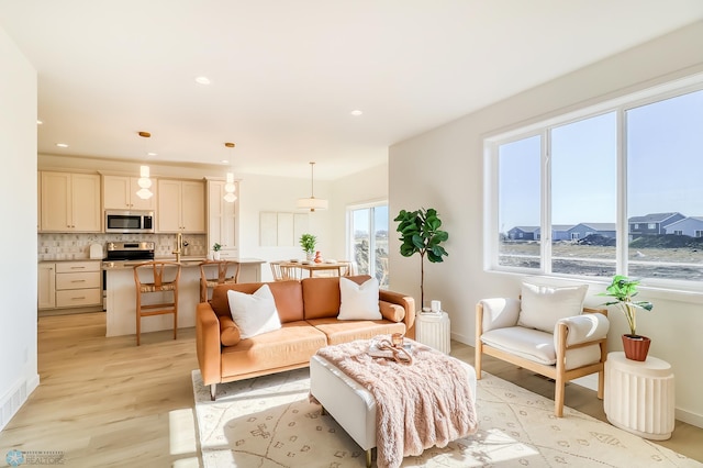 living area featuring recessed lighting, light wood-type flooring, and baseboards