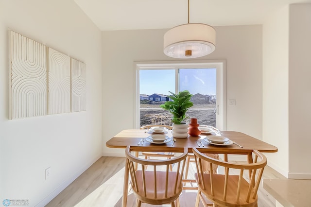 dining room featuring baseboards and light wood finished floors