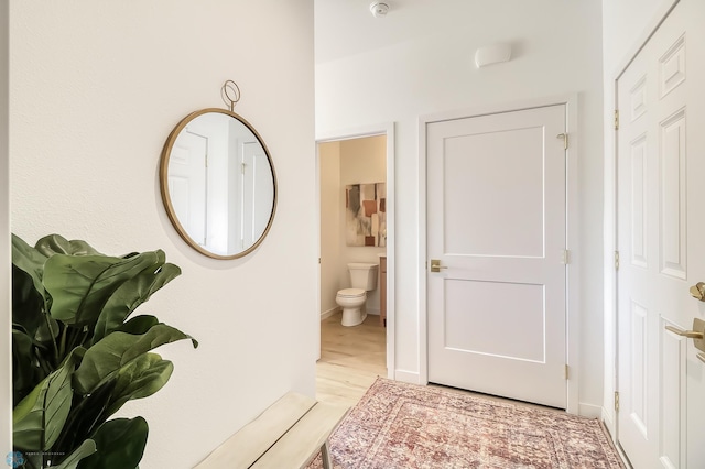 hallway with baseboards and light wood-style flooring