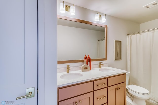 full bathroom with double vanity, toilet, visible vents, and a sink