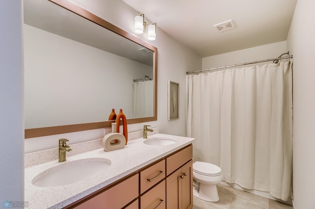 full bath with a sink, visible vents, toilet, and double vanity