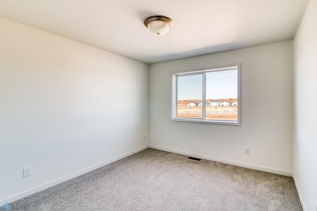 carpeted empty room with visible vents and baseboards