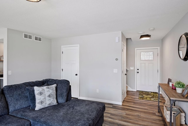 living area featuring dark wood finished floors, baseboards, and visible vents