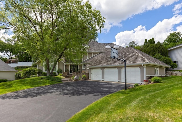 view of front of home with a garage, driveway, and a front lawn