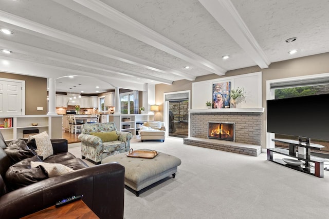 living room featuring beam ceiling, light carpet, a textured ceiling, recessed lighting, and a fireplace