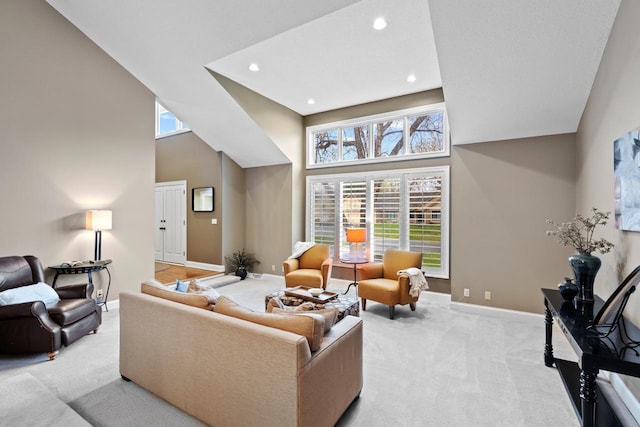 living room featuring a high ceiling, recessed lighting, baseboards, and light carpet