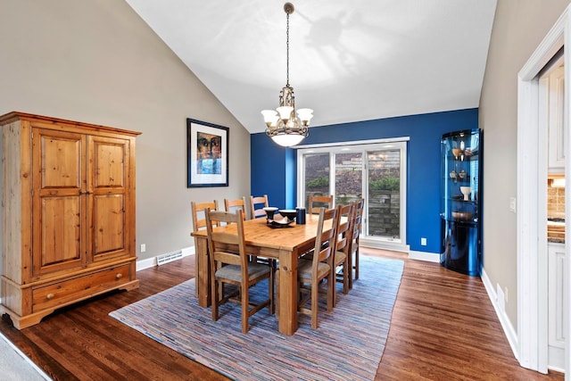 dining room with dark wood-style floors, visible vents, a chandelier, and vaulted ceiling