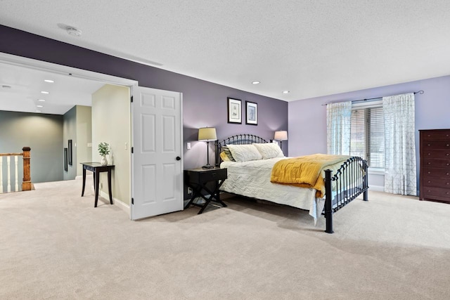 carpeted bedroom featuring recessed lighting, a textured ceiling, and baseboards