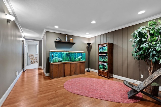 interior space featuring recessed lighting, baseboards, wood finished floors, and crown molding