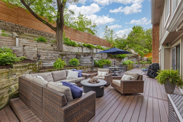 deck with an outdoor living space with a fire pit, outdoor dining area, and a fenced backyard