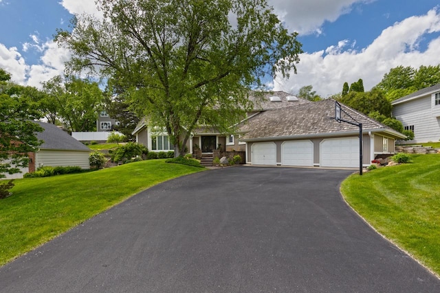 view of front of home with driveway, an attached garage, and a front lawn