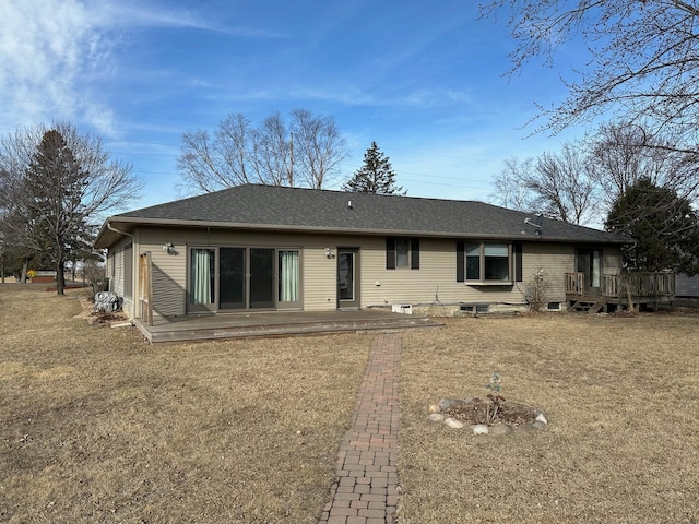 back of property featuring a shingled roof, a lawn, and a wooden deck