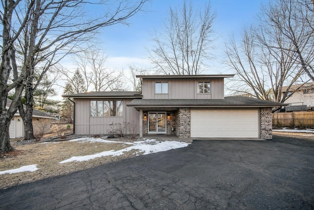 split level home featuring aphalt driveway, fence, and brick siding