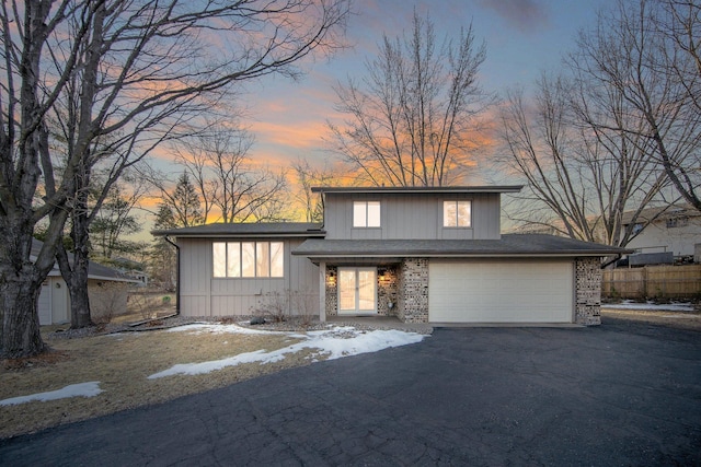 view of front of house with aphalt driveway, brick siding, and an attached garage