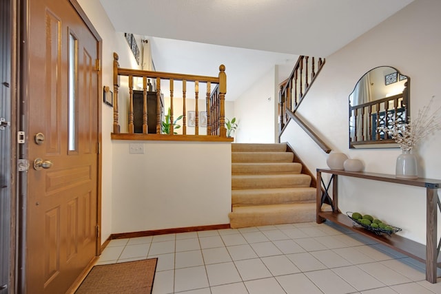 entryway with stairs, light tile patterned floors, and baseboards